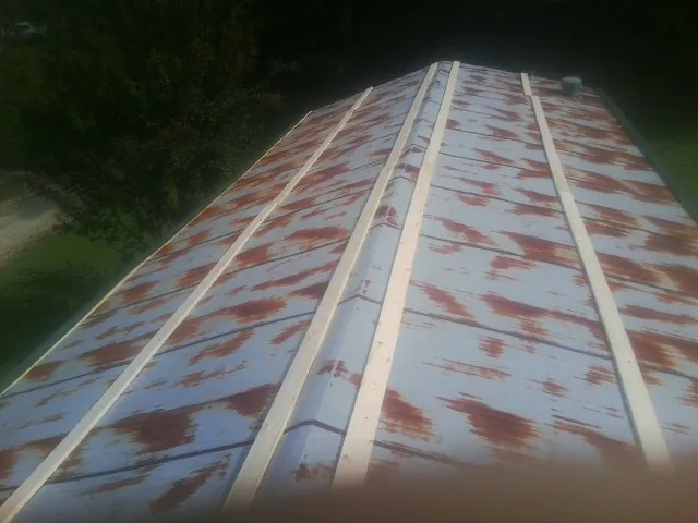 Rusted metal roof panels with new wood purlins before replacement in Hartsville