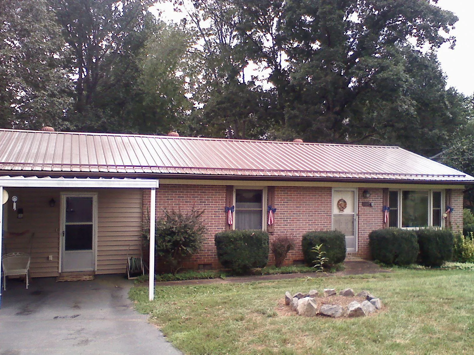 Bronze metal roof and carport on a brick ranch home — Roof Repair work by our crew in Hartsville